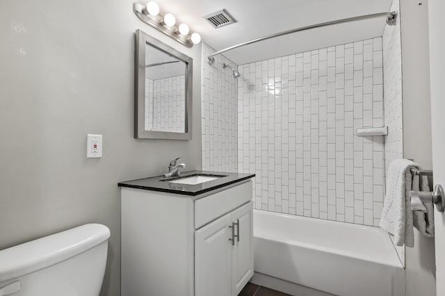 full bathroom with vanity, tiled shower / bath combo, and toilet