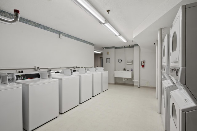 washroom with stacked washer / drying machine, sink, and washing machine and clothes dryer