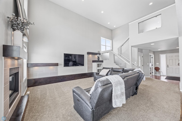 carpeted living room featuring a towering ceiling