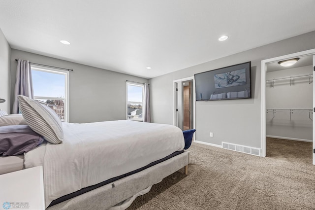 bedroom featuring a walk in closet, carpet, and a closet