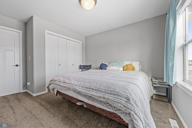 carpeted bedroom featuring multiple windows and a closet