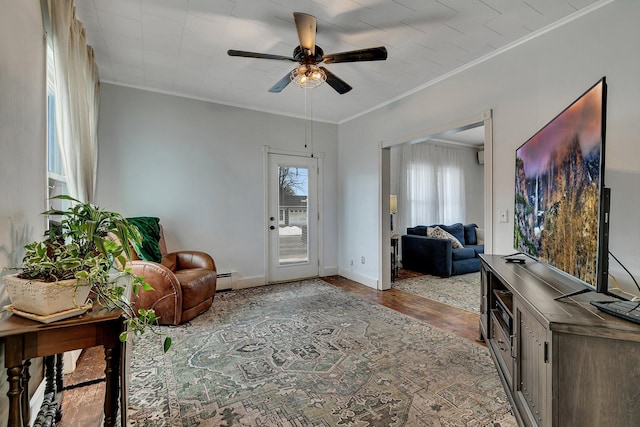 living room featuring crown molding, wood-type flooring, ceiling fan, and a baseboard radiator