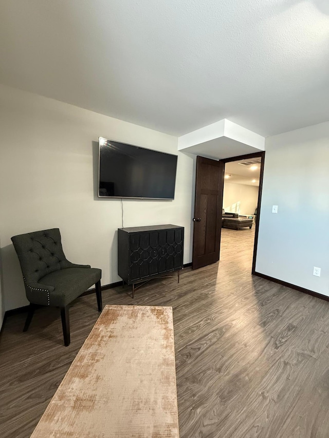 unfurnished room featuring hardwood / wood-style flooring and a textured ceiling