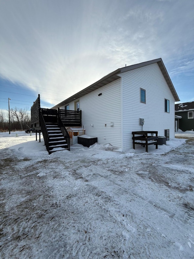 view of snow covered exterior featuring cooling unit