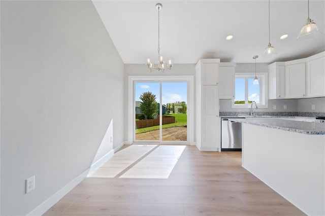 kitchen with stainless steel dishwasher, decorative light fixtures, light stone countertops, and white cabinets