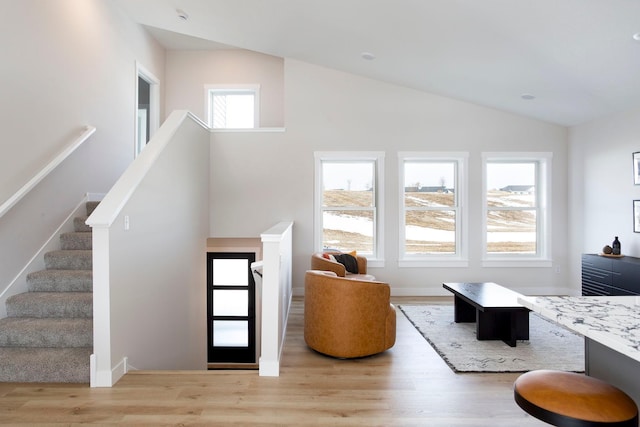 entryway featuring stairs, vaulted ceiling, plenty of natural light, and wood finished floors