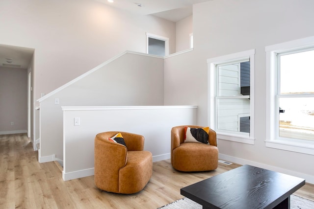 sitting room with visible vents, baseboards, and light wood finished floors