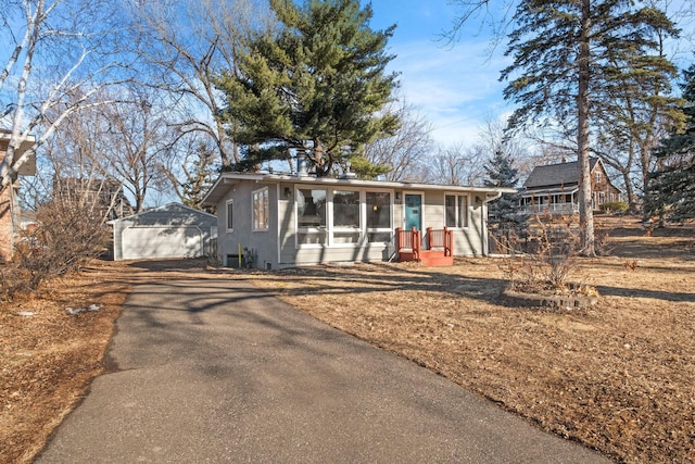 view of front of property with a garage and an outbuilding