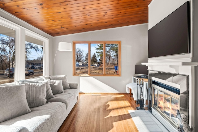 living room with a fireplace, vaulted ceiling, wooden ceiling, and light wood-type flooring