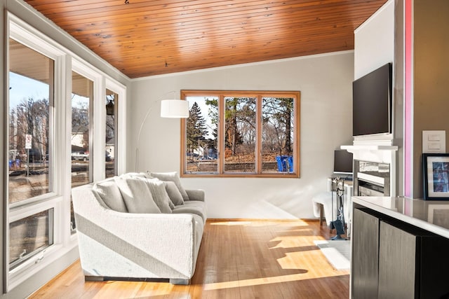 living room featuring crown molding, vaulted ceiling, light hardwood / wood-style floors, and wooden ceiling