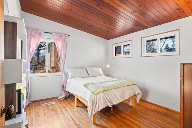 bedroom featuring light hardwood / wood-style flooring and wooden ceiling