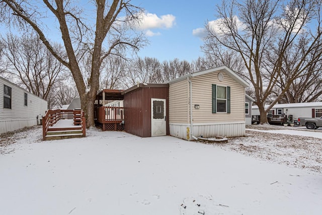 view of snow covered exterior with a deck