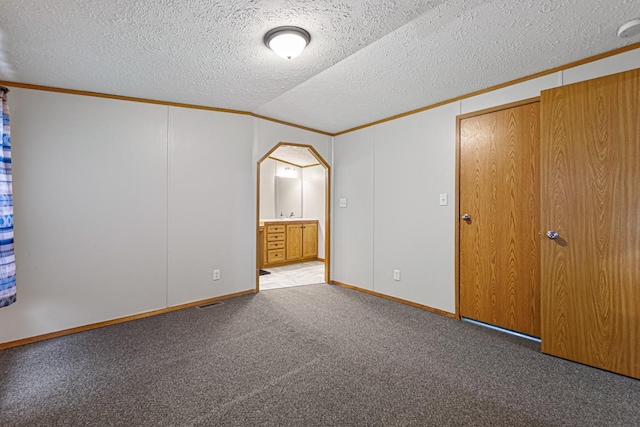 unfurnished bedroom featuring ornamental molding, light colored carpet, a closet, and vaulted ceiling