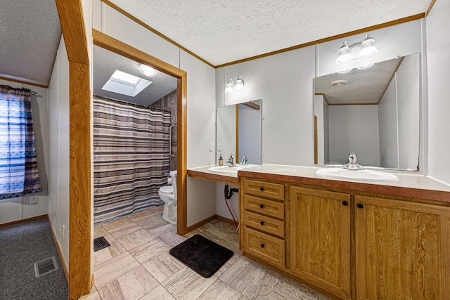 bathroom with sink, a skylight, ornamental molding, a textured ceiling, and toilet