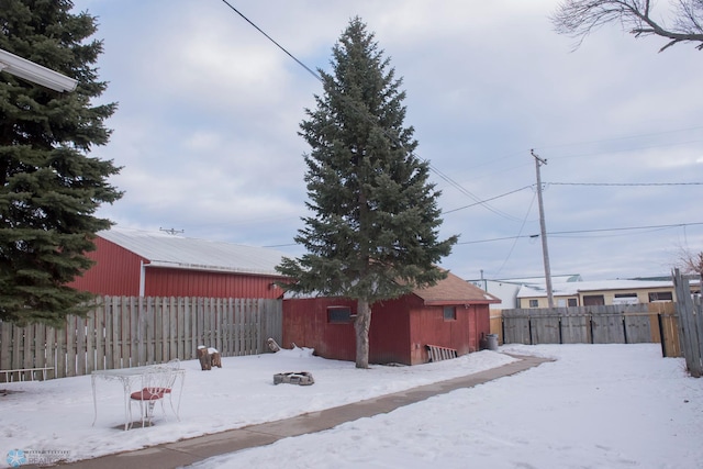 snowy yard with an outbuilding