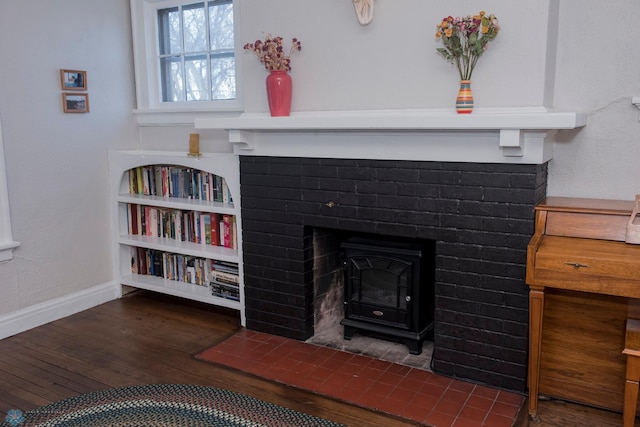 interior details with hardwood / wood-style flooring and a wood stove