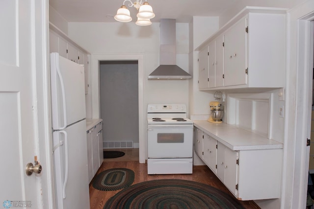 kitchen with an inviting chandelier, white cabinets, white appliances, and wall chimney exhaust hood