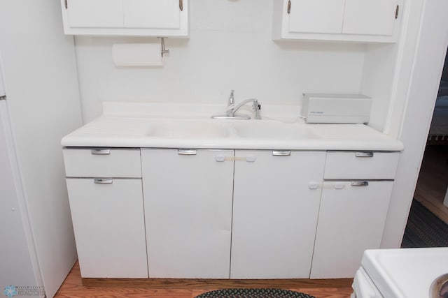 kitchen featuring sink, light hardwood / wood-style flooring, and white cabinets