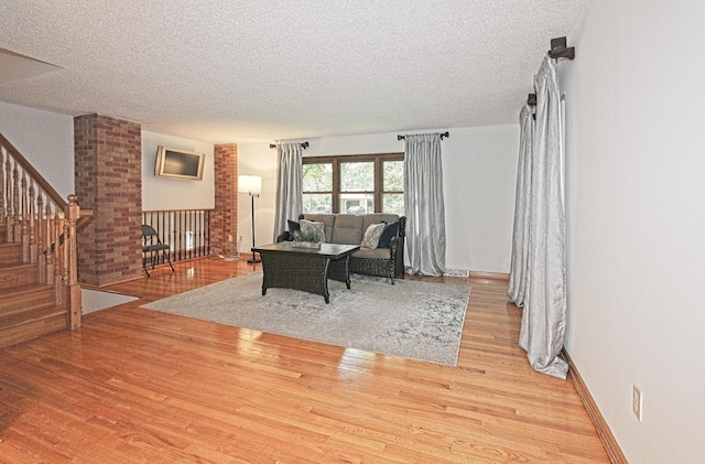 living room featuring a textured ceiling and light hardwood / wood-style flooring