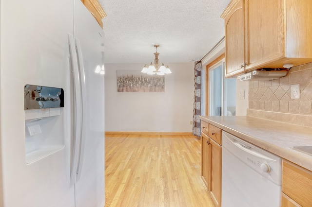 kitchen featuring tasteful backsplash, decorative light fixtures, light hardwood / wood-style flooring, light brown cabinets, and white appliances