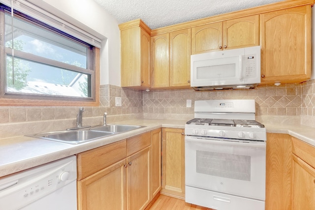 kitchen featuring light wood-type flooring, white appliances, sink, and light brown cabinets