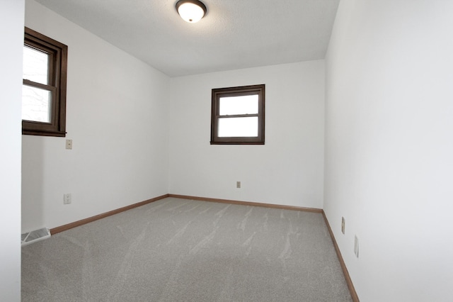 carpeted spare room featuring a textured ceiling