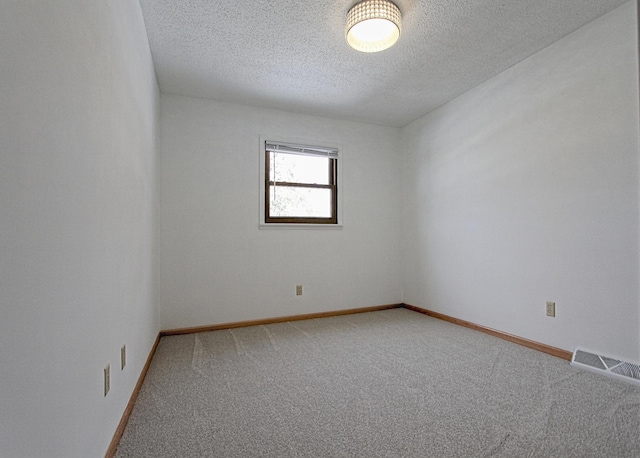 spare room featuring carpet floors and a textured ceiling