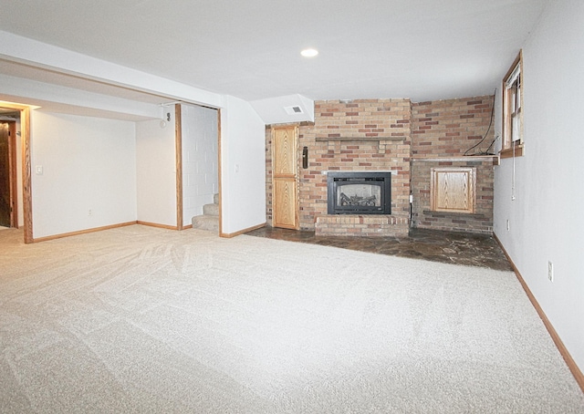 unfurnished living room featuring carpet floors and a brick fireplace