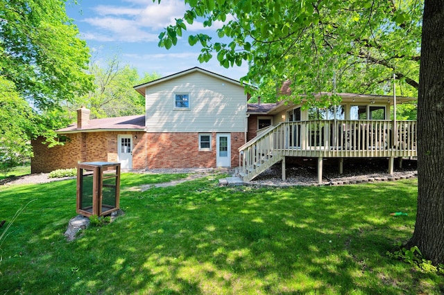 rear view of property with a yard and a deck