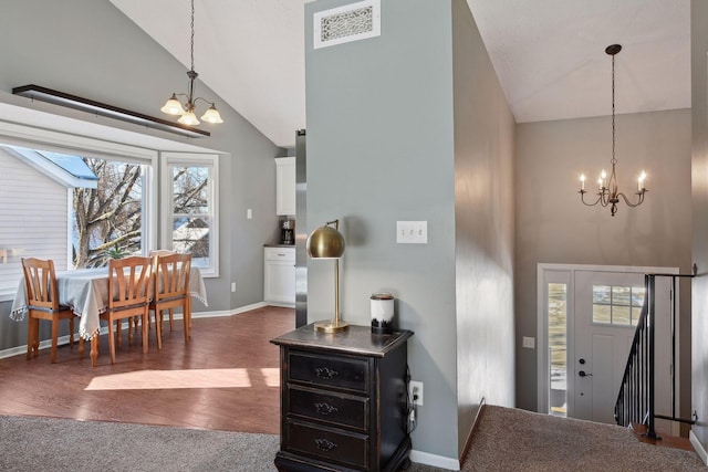 foyer entrance featuring a chandelier, dark wood finished floors, visible vents, and baseboards