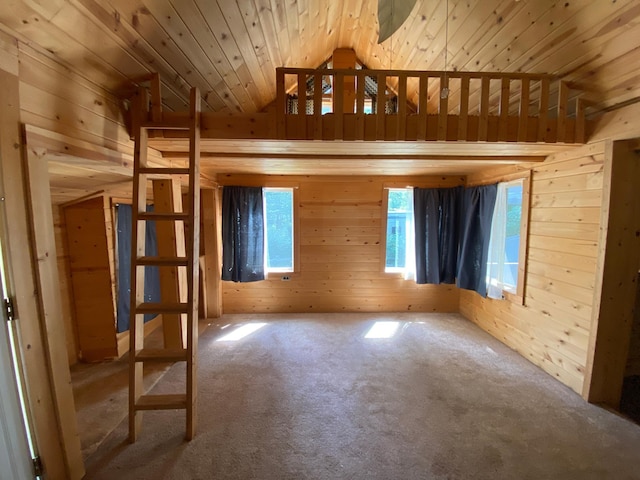 empty room featuring wood ceiling, wooden walls, and carpet flooring