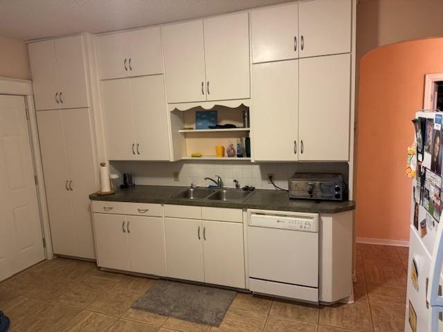 kitchen featuring white dishwasher, sink, and white cabinets