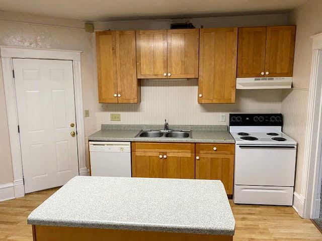 kitchen with sink, white appliances, and light wood-type flooring