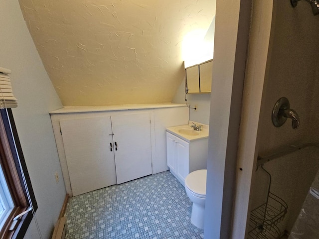 bathroom with vanity, toilet, vaulted ceiling, and a textured ceiling