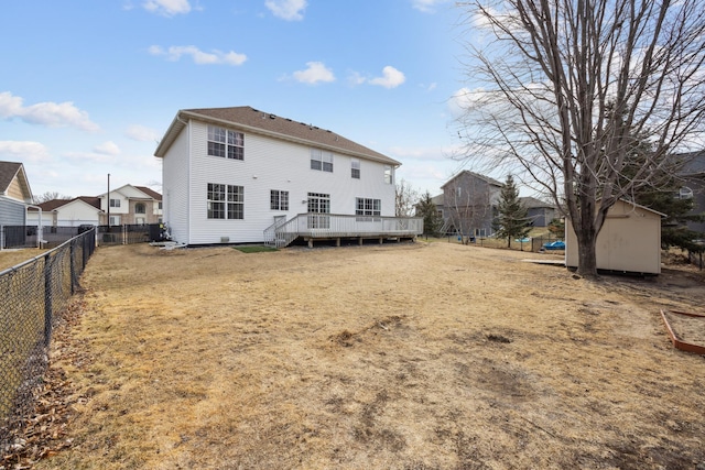 rear view of property with a deck, a storage unit, an outdoor structure, and a fenced backyard