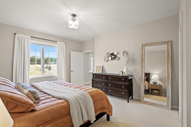 bedroom with light carpet and a textured ceiling