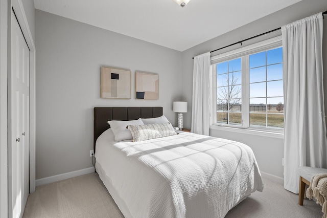 bedroom with light carpet and a closet