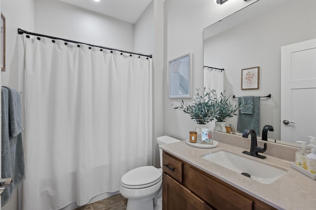 bathroom featuring tile patterned flooring, vanity, and toilet