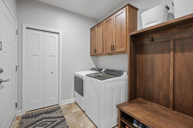 clothes washing area featuring cabinets and washer and clothes dryer