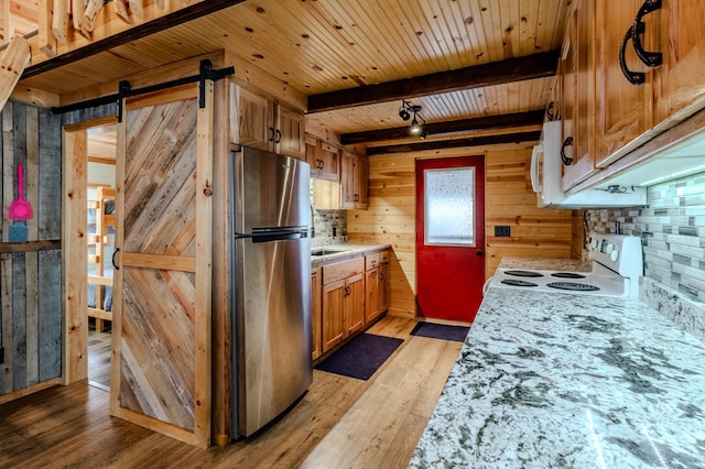 kitchen with wood ceiling, electric range, stainless steel fridge, beamed ceiling, and a barn door