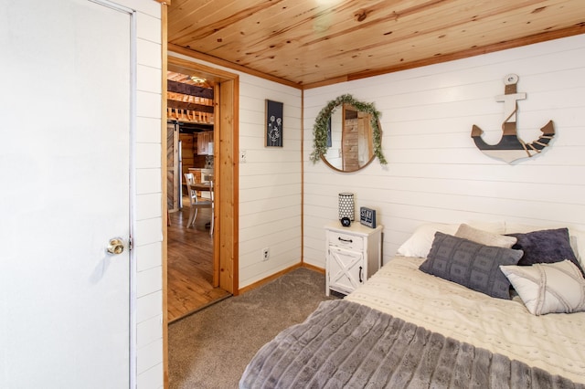 bedroom featuring wood ceiling, carpet, and wood walls