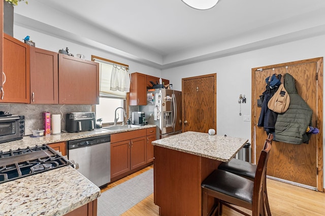 kitchen featuring appliances with stainless steel finishes, a kitchen island, and light stone countertops