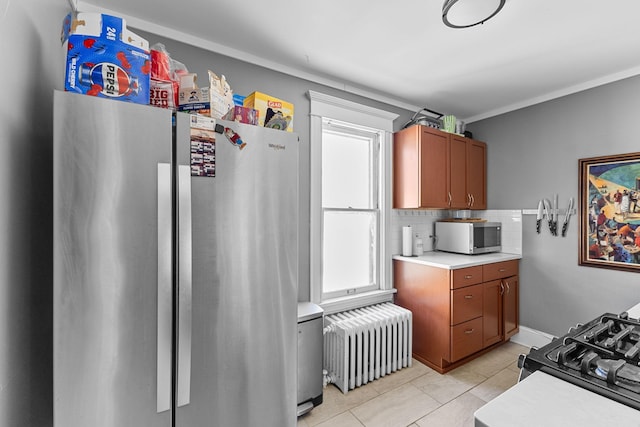 kitchen featuring radiator, tasteful backsplash, appliances with stainless steel finishes, and light countertops