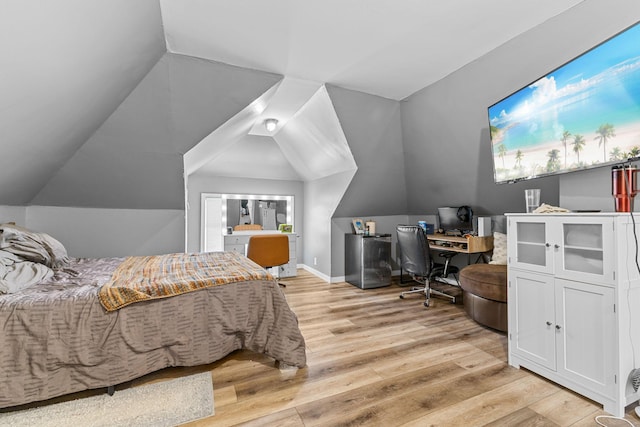 bedroom featuring light wood-style floors, lofted ceiling, and baseboards