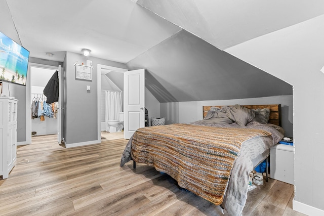 2707 Fremont Ave S, Minneapolis, MN 55408 - bedroom featuring light wood finished floors, a walk in closet, lofted ceiling, and ensuite bath