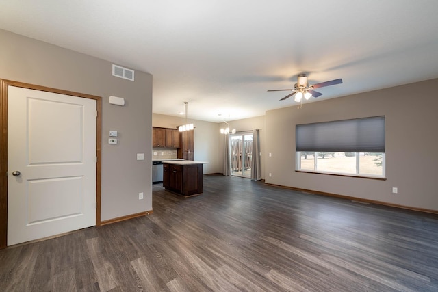 unfurnished living room with ceiling fan with notable chandelier and dark wood-type flooring