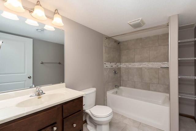 full bathroom featuring tiled shower / bath combo, vanity, toilet, tile patterned floors, and a textured ceiling