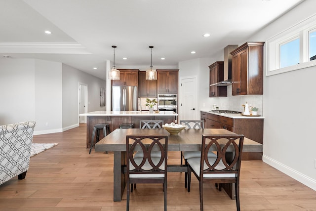 dining room featuring crown molding and light hardwood / wood-style floors