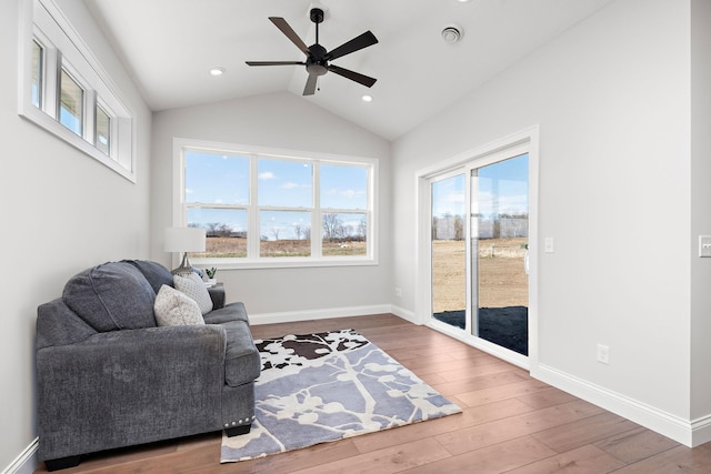 living area featuring lofted ceiling, hardwood / wood-style floors, plenty of natural light, and ceiling fan