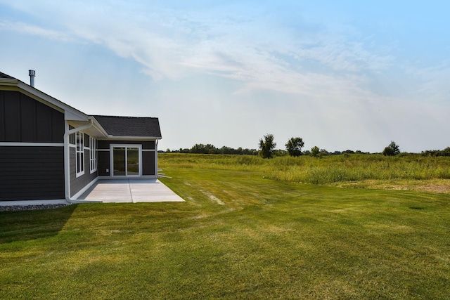 view of yard with a rural view and a patio